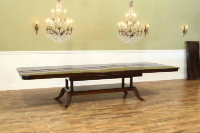 Expandable mahogany dining table on platform pedestal shown here with 2 of 3 leaves in place