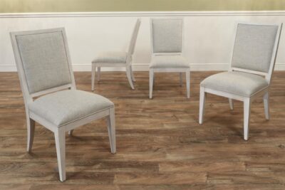 Whitewashed upholstered dining room chairs with neutral fabric