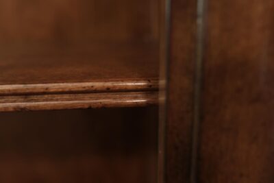 The top shelf has a glass insert, so the light can pass through and reach the lower part of bookcase