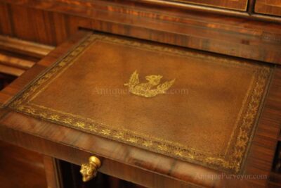 Two slide out trays with leather tooling and lion head drawer pulls below glass doors