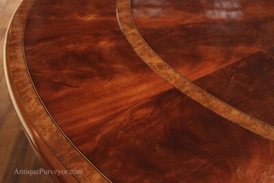 Extra large mahogany table with banding and perimeter leaves, expands to seat 10-12 people.